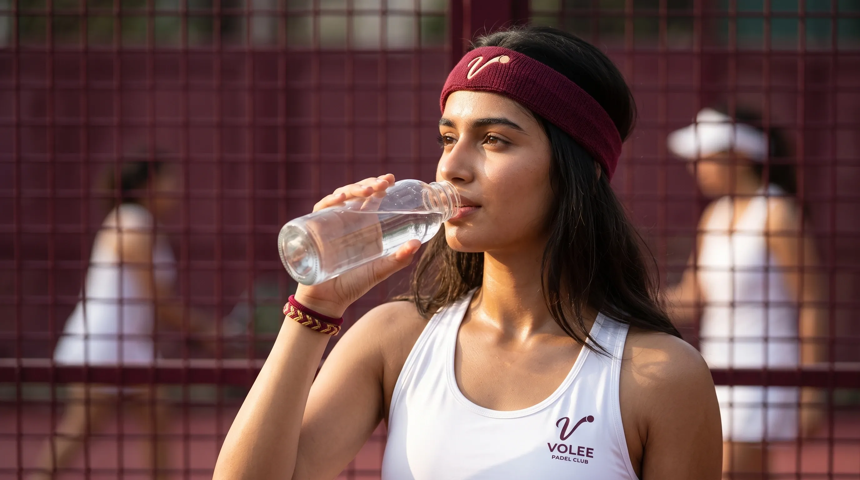 A member in a maroon club headband drinks between games